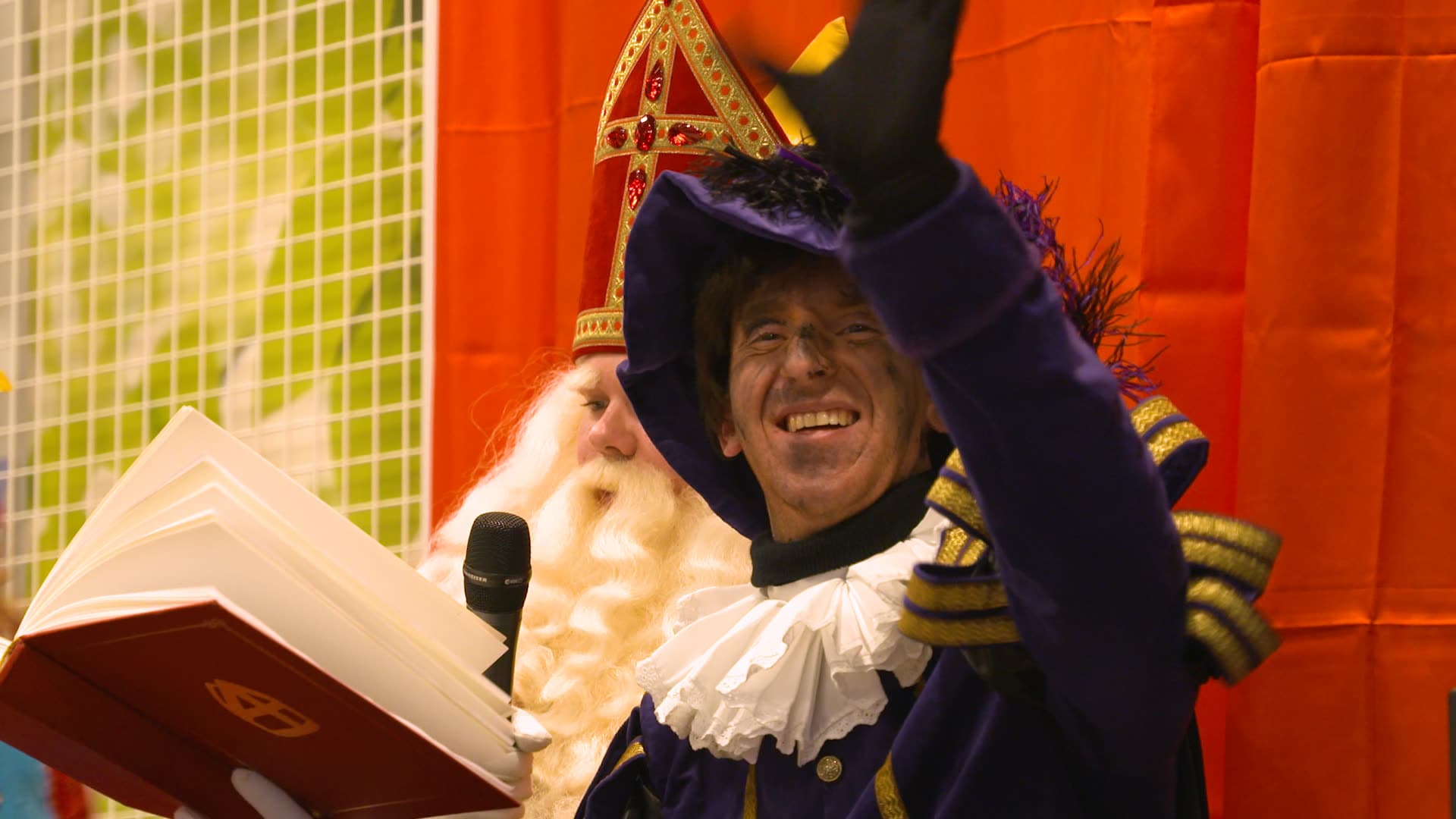 Piet leest voor uit het Grote Boek en zwaait enthousiast